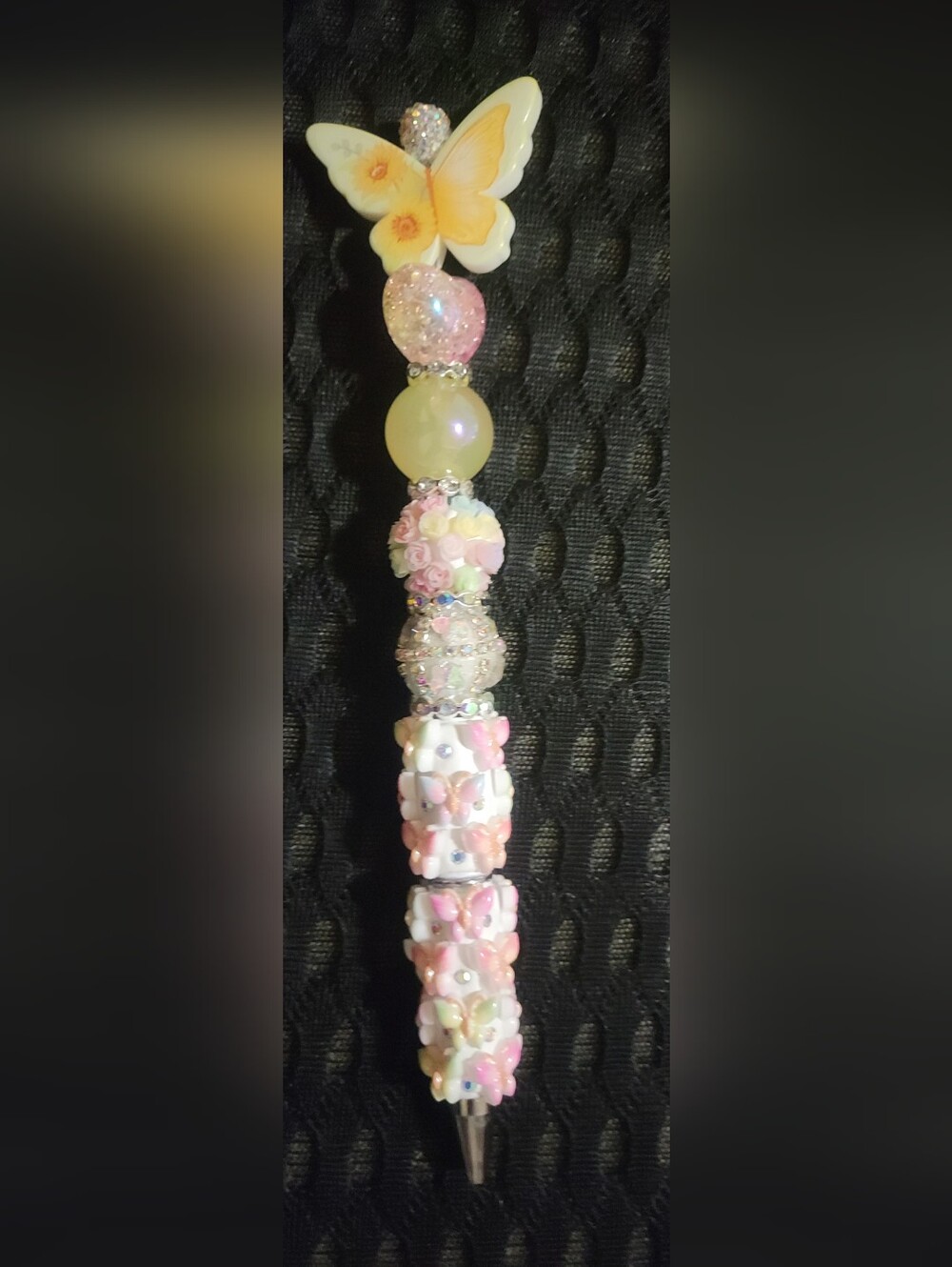 Handmade beaded ballpoint pen decorated with a pastel butterfly and floral theme